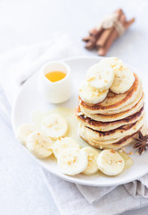 Pancakes with banana, honey and nuts on ceramic plate. Perfect breakfast.
