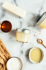 Jars of honey butter with ingredients on marble background