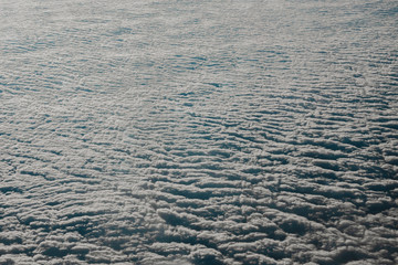 Sky cloudy overcast. Clouds texture background. View on blue clouds from above. View from airplane. Layer of clouds top view.