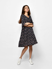 Fototapeta premium Young beautiful woman posing in new fashion long casual summer dress happy smiling walking dancing on gray 