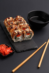 Sushi rolls on colored plates on a black background. A look from above.