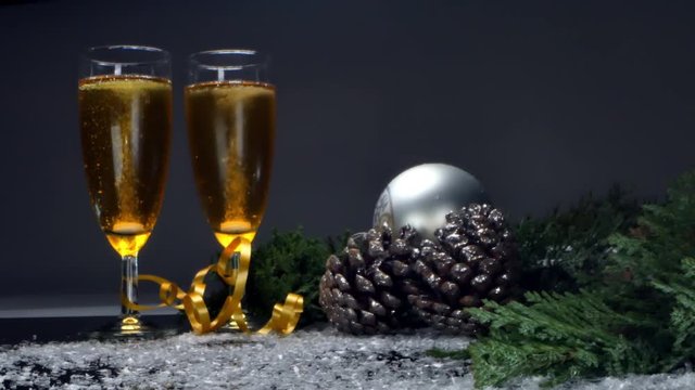 two glasses of champagne with christmas tree and balls for new year