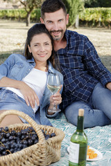 happy woman and man on picnic drinking wine