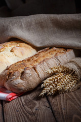 Assortment of baked bread on wooden table background