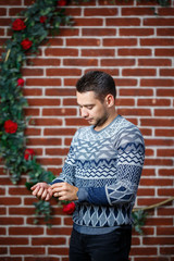 young guy in a sweatshirt against a brick wall