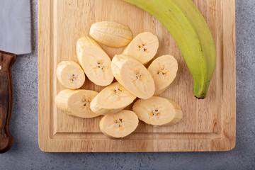Cooking with plantains, cut slices on a cutting boards © fahrwasser