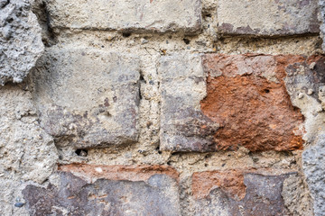 Texture of an old brick wall with crumbling plaster.