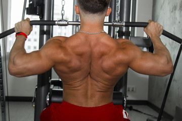 Men's inflated back closeup. Gym. Body-builder. Beautiful, swollen male body. Trainer, advertising, healthy lifestyle. Bodybuilder. The concept of sports.