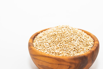 Raw quinoa in a wooden bowl isolated on white background with copy space