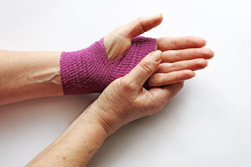 Eine Frau hat eine verletzte Hand mit einem Verband