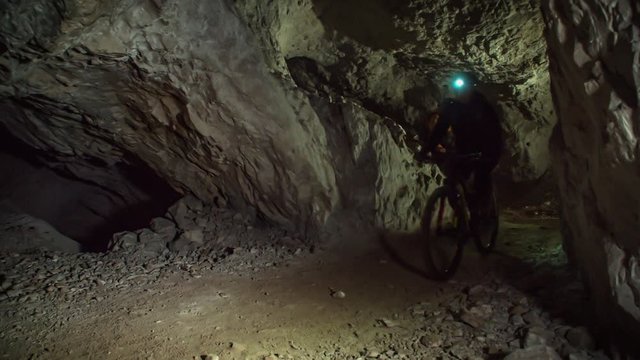 Underground mountain biking through tight spaces. Underground cave activity. Mežica, Slovenia