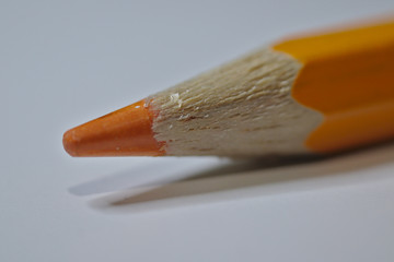 Orange pencil sitting on white desk