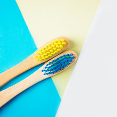 Yellow and blue bamboo toothbrushes. Eco-friendly concept. Minimal, geometric background. Top view, copy space