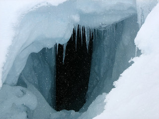 Cave in a deep snow high in the mountain