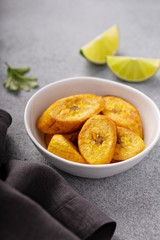 Fried plantains with fresh lime in the background, carribean cuisine © fahrwasser