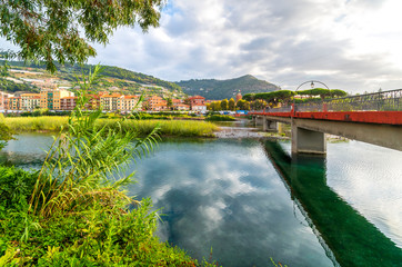 Fototapeta premium View of a bridge spanning the Roya River on the Mediterranean Riviera coast of Italy with the town of Ventimiglia, Italy on the other side.