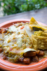 Fresh made Tex-Mex plate of huevos rancheros breakfast plate of eggs with cheese and green sauce with tortilla chips