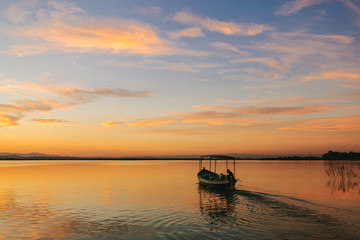 Nice sunset on the lake of the Albufera of Valencia with a boat sailing