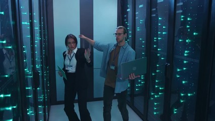 Happy team of data center having fun inside server room, dancing enjoying music rhythm in high tech environment. Teamwork. Fun scene.