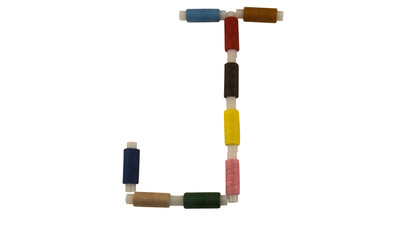Isolated Font English or Latin Letter J made of colorful spools of thread for sewing on white background
