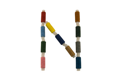 Isolated Font English or Latin Letter N made of colorful spools of thread for sewing on white background