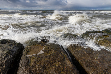 Sea waves crashing against the concrete quay. A Baltic storm in Central Europe.