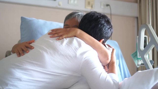 Happy Woman Visits Best friends holding hands for recovering that sick lying in Hospital, looking with cheerful love hopeful emotional, Encouragement comforting Recovering from family healthy moment.
