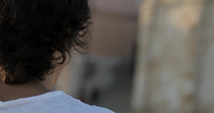 360 degrees portrait shot of attractive guy, young man, looking at camera and turning around while smiling. Tourist or student lifestyle.