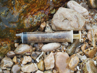 Used syringe Fall on the rocks