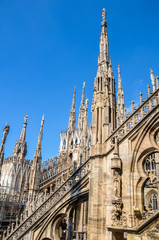 Amazing view of Cathedral roof Duomo di Milano, Beautiful luxurious top of Cathedral with rows of Gothic pinnacles and sculptures on the sky background. It is a main landmark of Milan, Italy
