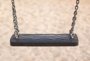 closeup of empty black swing in a park