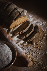 dark sliced ​​bread with wheat and flour on the table. Sliced ​​rye bread on a close-up on...