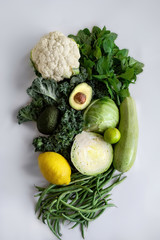 Mix of fresh vegetables and fruits, Avocado, kale, cabbage, cauliflower, lemon, lime, mint, green beans, zucchini. Healthy vegetarian and raw food. On isolated white. Natural eco farmer.