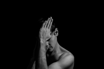 young man on a black background in a dramatic expressive pose
