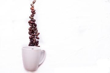 cocoa beans simulating chocolate smoke from a white cup