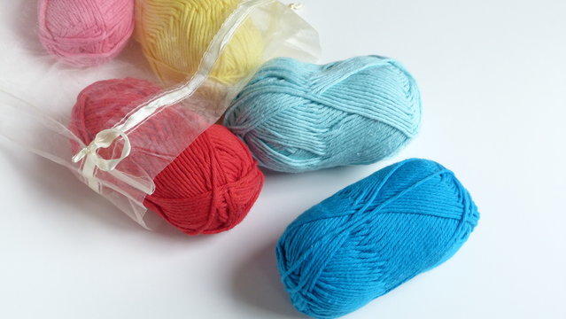 Colorful Yarn in a Soft Drawstring Bag on a White Background | Red, Pink, Yellow, and Blue Yarn
