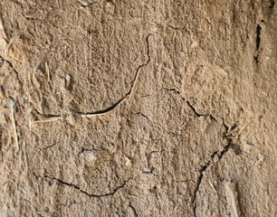 dry and cracked adobe texture, organic and ecological  - closeup background with clay, mug and straw