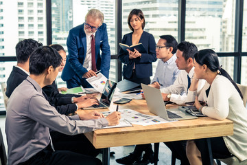 Group of Asian business people man and woman employee meeting with CEO or manager advisor briefing and discussing teamwork business plan in office meeting room. Business team meeting seminar concept.