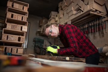 Busy young craftsman working in his workshop