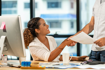 Happy young smart business man and woman partnership shaking hands with smiling after get a good...