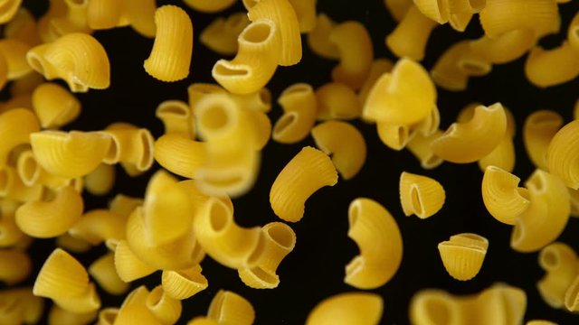 Super slow motion of flying uncooked italian pasta chifferi on black background. Filmed on high speed cinema camera, 1000 fps.
