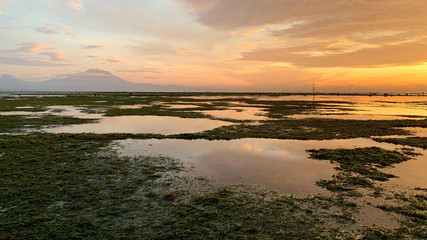 バリ島サヌール浅瀬から見るアグン山と日の出朝焼け 