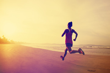 Fototapeta na wymiar Fitness woman runner running on sunrise beach