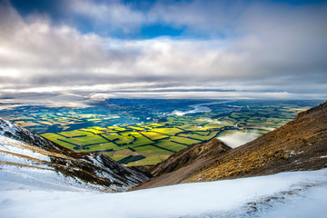 Winter New Zealand landscape in the mountains. View from Mt Hutt New Zealand overlooking canterbury plains. Scenic amazing landscape view in winter from mountain peaks. - obrazy, fototapety, plakaty