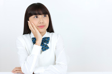 頬に手をあてる女子学生