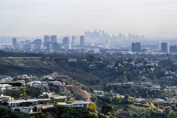 Obraz premium Canyon homes with hazy smoggy cityscape view of Century City and Downtown Los Angeles skylines. 