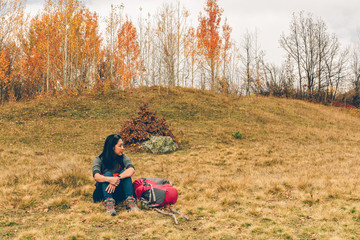 Woman is hiking in colorful nature scenic of forest and hills.