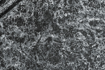 Texture of black rice paper with white streaks on it. Rice paper with creases cracks and spots.