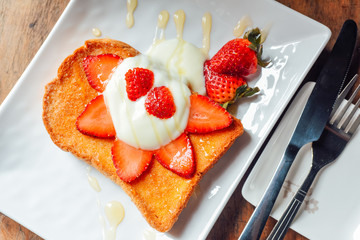 Toast with Yogurt , strawberry and  honey  in  white plate on  wooden table, Breakfast baked