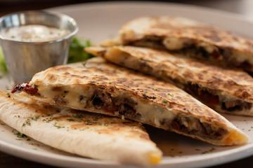 Steak Quesadilla with Monterey Jack Cheese, Jalapeños, Red Chiles, and Onions with Sour Cream on the Side